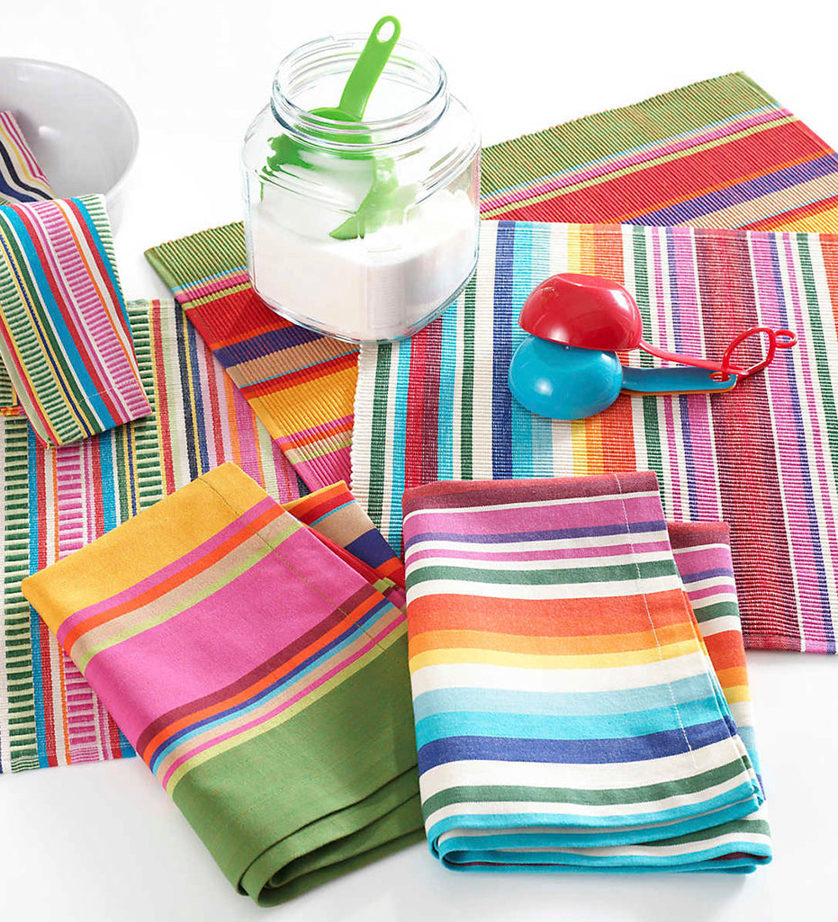 Decorated tabletop including: Paxton Stripe Napkins, Paxton Stripe Placemats, measuring cups, and a jar of sugar. 